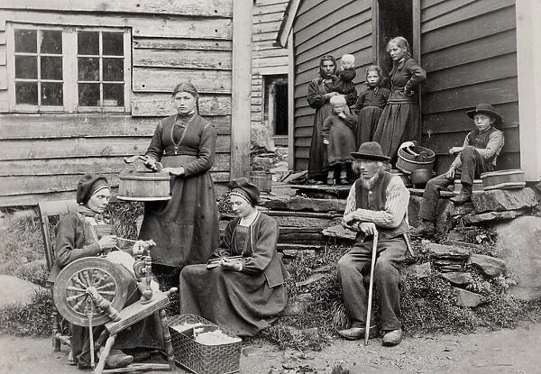 Norway, rural family outside home with spinning wheel