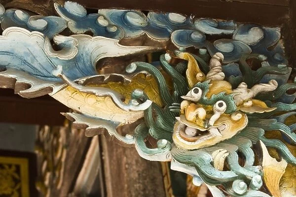 Vietnam, Hoi An, ornately carved wooden bracket depicting Vietnamese dragon, above doorway