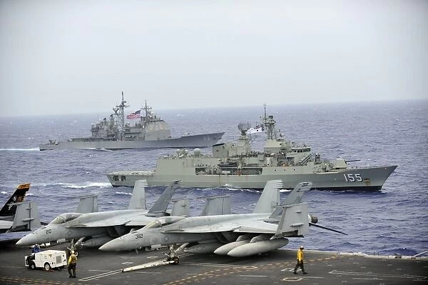 HMAS Ballarat of the Royal Australian Navy cruises alongside US Navy ships