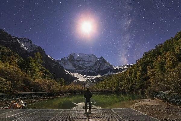 The Milky Way and waxing cresent moon over Mount Chenrezig in China