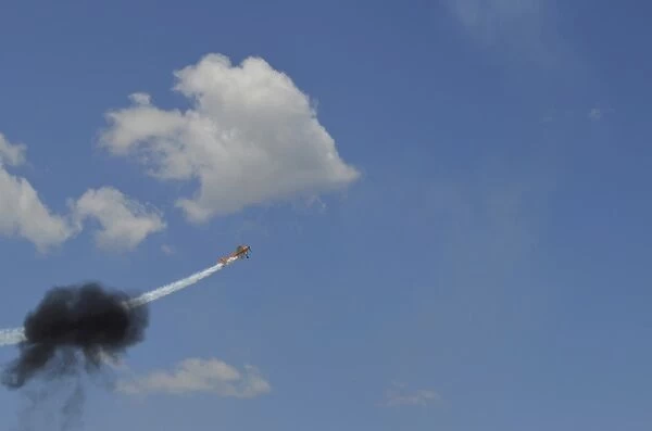 A Yakovlev Yak-55M aerobatic aircraft flys through a smoke ring