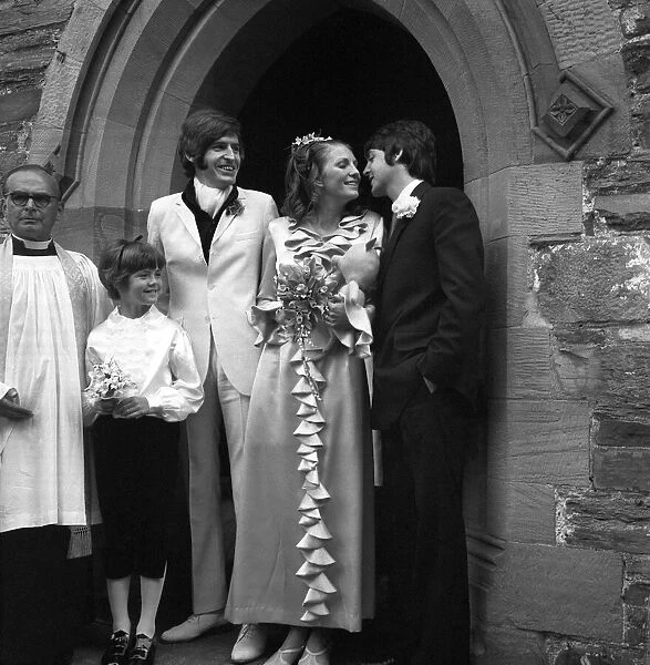 Mike McCartneys Wedding. A kiss for the bride from Paul McCartney watched by
