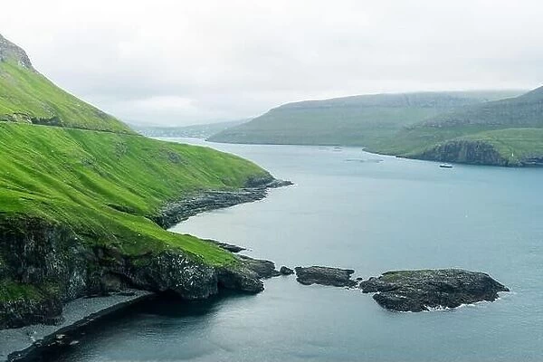 Dramatic view of green hills of Vagar island and Sorvagur town