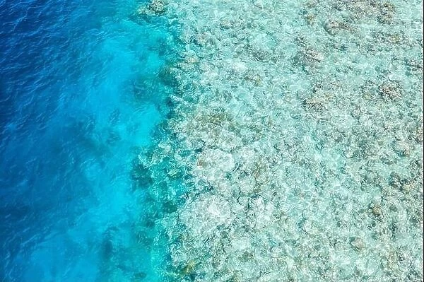 Top view from drone at ocean, azure water and relax blue sea. Vacation and adventure. Turquoise water coral reef texture, shallow and deep ocean