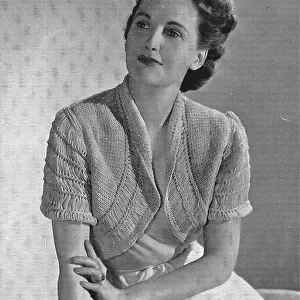 Model wearing a knitted bolero jacket. Date: 1940