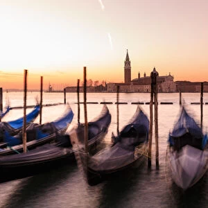 Beautiful Venetian sunrise in winter, gondolas, San Giorgio Maggiore and Lido, Venice