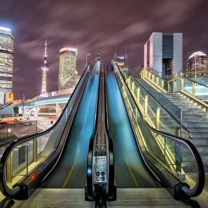 A modern, open-air escalator with Pudong cityscape at night, Shanghai, China, Asia