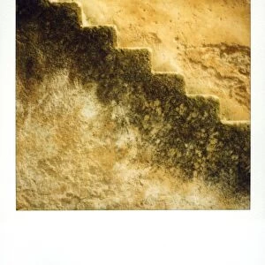 Polaroid of stone stairs against old stone wall glowing