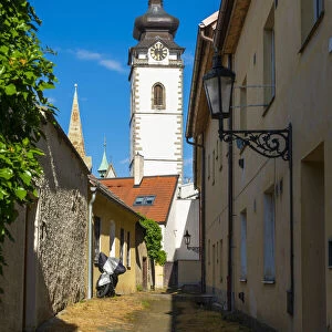Lane towards tower of Church of the Nativity of the Blessed Virgin Mary on sunny day, Pisek, South Bohemian Region, Czech Republic