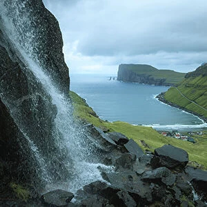 A part of the village of Tjornuvik seen from the mountain. In the background the Rising and Kellingin sea stacks. Island of Streymoy. Faroe Islands