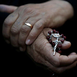 An Iraqi Christian woman holds a cross during a prayer session inside the Syriac Orthodox