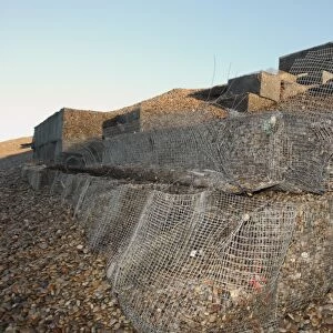 Storm damage to shingle filled wire gabions on beach, Chesil Beach, Dorset, England, January