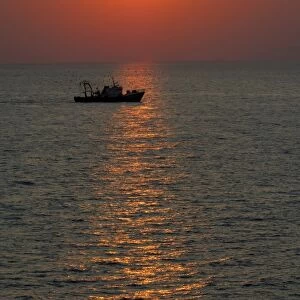 Europe, Greece, Crete (aka Kriti). Aegean sunset with Greek fishing boat