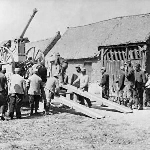 WWI: ARMORED CAR, c1915. Soldiers unloading an armored car in a village. Photograph