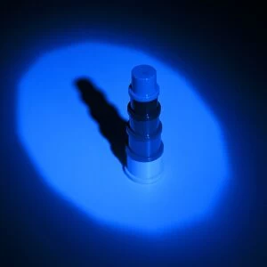 Blue light shining on object in dark causing black shadow