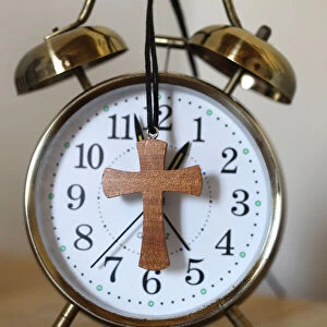 Old-fashioned vintage copper alarm clock with christian cross