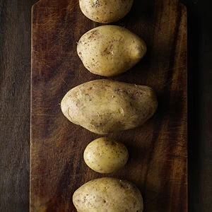 Organic potatoes on a vintage wooden cutting board, Italy, Europe