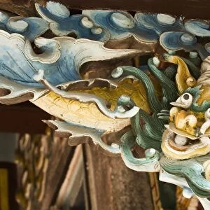 Vietnam, Hoi An, ornately carved wooden bracket depicting Vietnamese dragon, above doorway