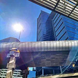 Futuristic global city, office buildings, highway overpass with sun and lens flare