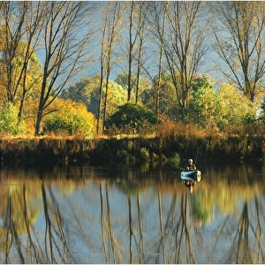 Lone fisherman with reflections of the Autumn, near Mount Beauty, in the high country of Victoria