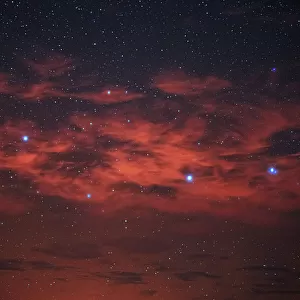 Starry night sky with red clouds