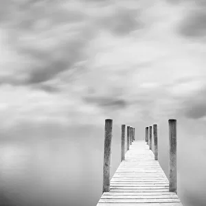 Jetty against cloudy sky