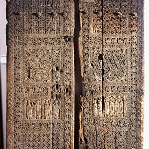 A pair of carved Armenian walnut doors, depicting Christ with six Apostles and Saints