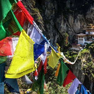 Prayer flags span the chasm before the Tiger's Nest Monastery