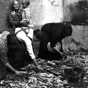 Belgian women search the rubble of their homes for their belongings after the battle at