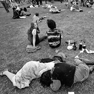 Hyde Park Pop Festival. Couple oblivious to the surroundings embrace by empty wine