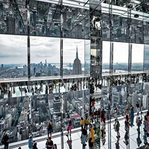 USA, New York City, Manhattan, Summit Building, mirrored view of people walking on glass floor, Empire State Building and Manhattan in the background